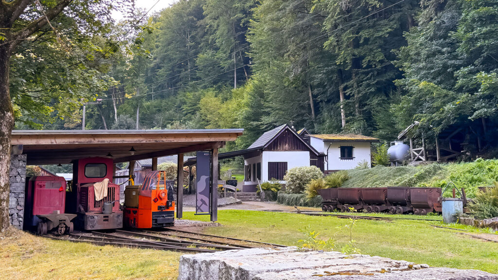 Eine alte Grubenlok steht vor einem Haus, das zum Besucherbergwerk Rabensteiner Stollen gehört.