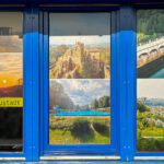 Drei Fenster mit blauen Rahmen, ausgefüllt mit Bildern aus Neustadt im Harz sowie einem Monitor.