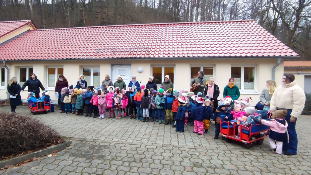 Alle Kinder und die Erziehenden stehen warm angezogen vor einem Flachbau der Gemeinde Harztor.