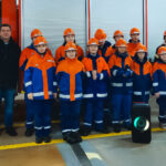 Gruppenbild von jungen Feuerwehrleuten mit zwei erwachsenen Ausbildern sowie einem Mann in Zivilkleidung