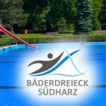 Das Bild zeigt ein lebhaftes Freibad mit einer roten Rutsche und dem Logo von „Bäderdreieck Südharz“ darüber. Das Schwimmbad ist von Grünflächen und parkähnlichen Einrichtungen umgeben.